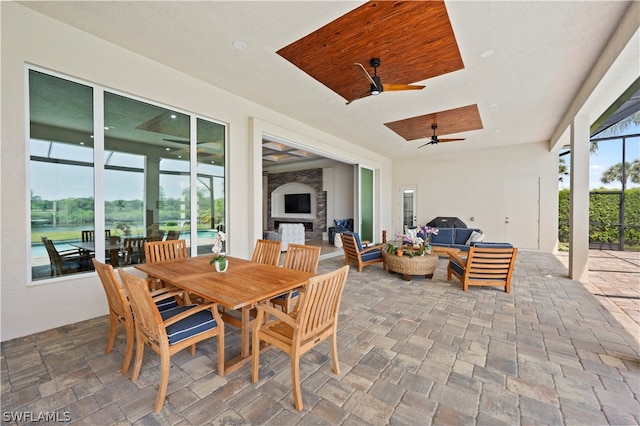 view of patio featuring ceiling fan and an outdoor living space with a fireplace