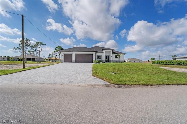 view of front of house featuring a garage and a front lawn