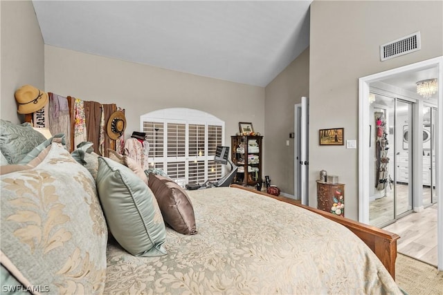 bedroom featuring stacked washer / dryer, a closet, and vaulted ceiling