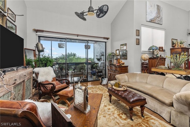 living room featuring hardwood / wood-style flooring, high vaulted ceiling, and ceiling fan