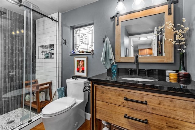 bathroom featuring baseboard heating, a shower with door, vanity, and toilet