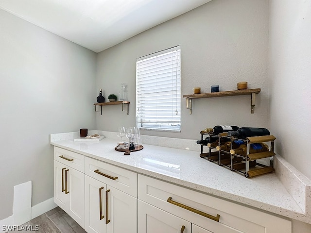 interior space featuring white cabinetry and light stone counters