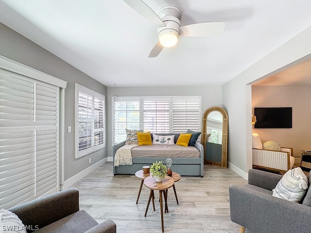 living room with ceiling fan and light wood-type flooring