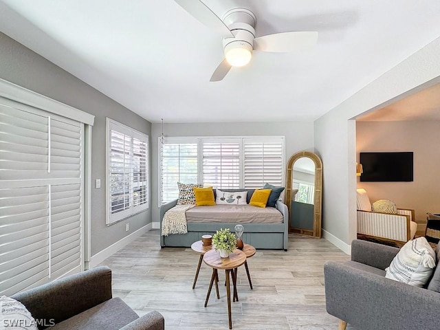 bedroom featuring light wood finished floors, baseboards, and a ceiling fan