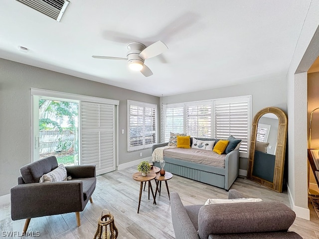 living room with ceiling fan and light wood-type flooring