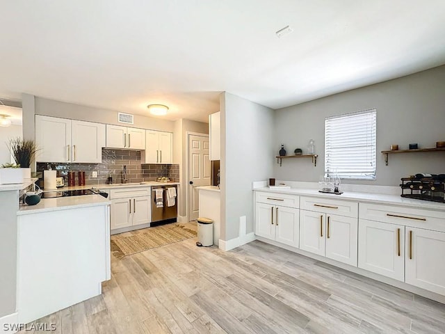 kitchen with a sink, dishwasher, white cabinets, and backsplash