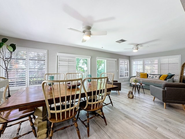 dining area with light wood-type flooring and ceiling fan