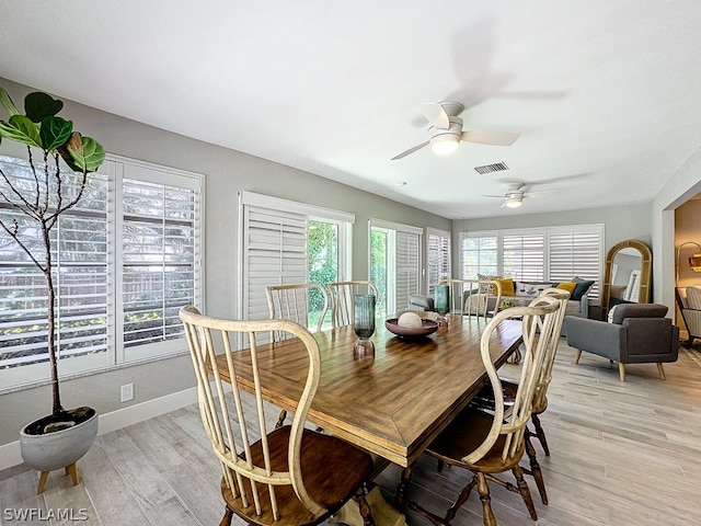 dining space with ceiling fan and light hardwood / wood-style flooring