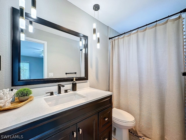 bathroom with oversized vanity, toilet, and ceiling fan