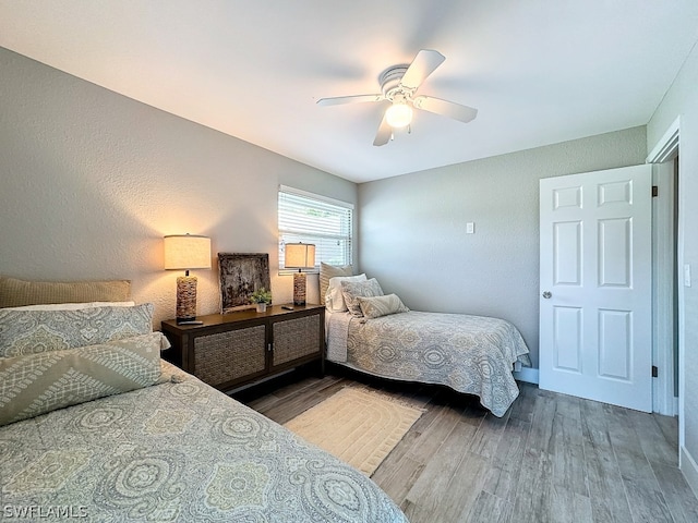 bedroom with dark hardwood / wood-style flooring and ceiling fan