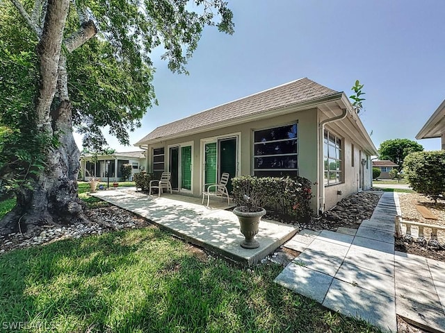 rear view of property with a patio and stucco siding