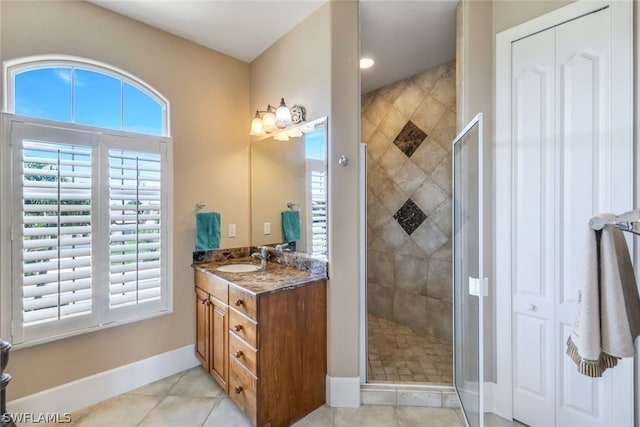 bathroom with an enclosed shower, vanity, and tile patterned flooring