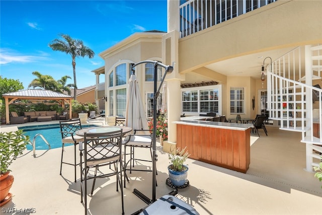 view of patio / terrace with a gazebo, exterior bar, and an outdoor living space