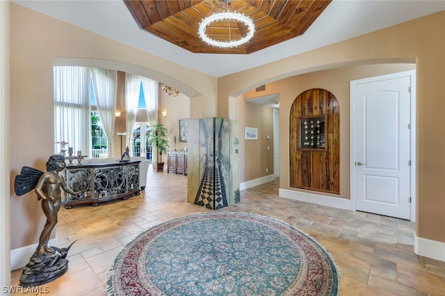 foyer with wooden ceiling and a raised ceiling