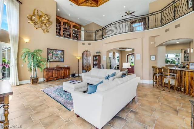 living room with a towering ceiling and ceiling fan