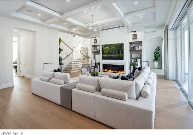 living room with light hardwood / wood-style floors, a notable chandelier, coffered ceiling, beamed ceiling, and crown molding