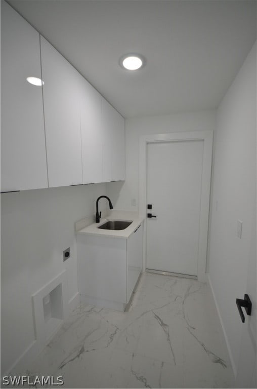 clothes washing area featuring cabinets, sink, and hookup for an electric dryer