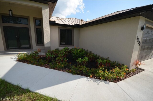 view of home's exterior with a garage and french doors