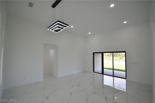 tiled spare room with a high ceiling