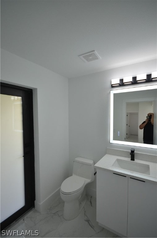 bathroom featuring tile floors, vanity, and toilet