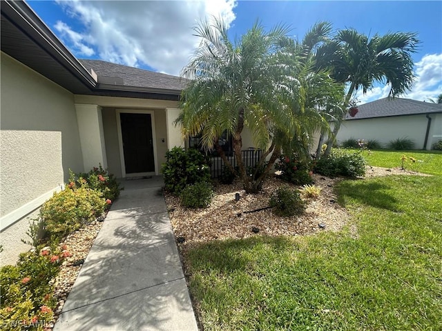 doorway to property with a yard