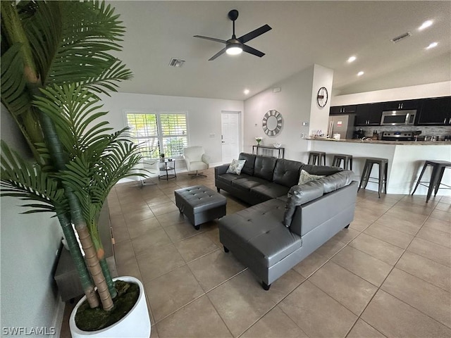 tiled living room with ceiling fan and vaulted ceiling