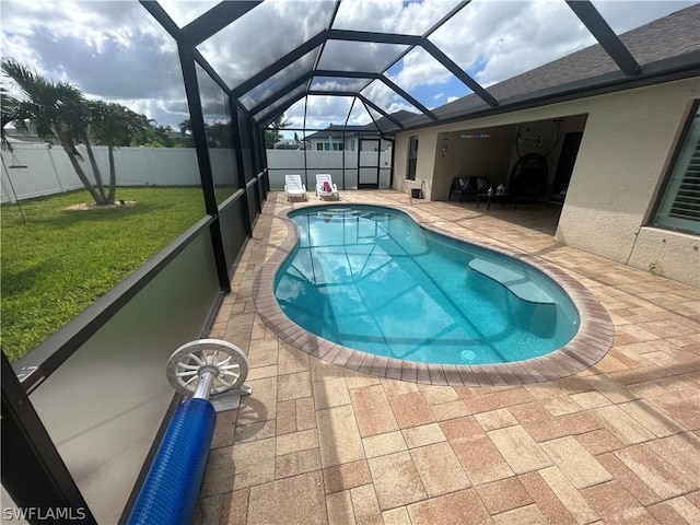 view of swimming pool with a lawn, a patio area, and glass enclosure