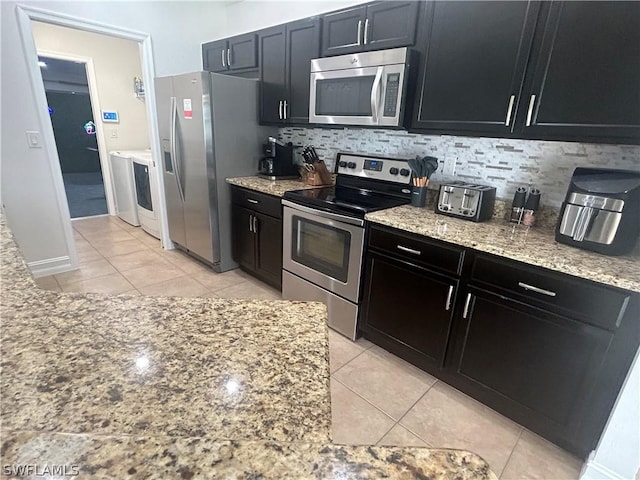 kitchen with light tile patterned floors, light stone countertops, backsplash, and appliances with stainless steel finishes