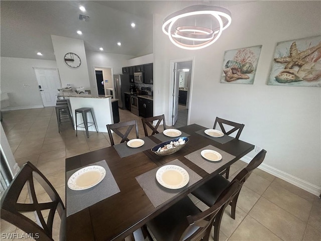 tiled dining area featuring a high ceiling and a notable chandelier