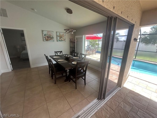 dining room with tile patterned floors and vaulted ceiling