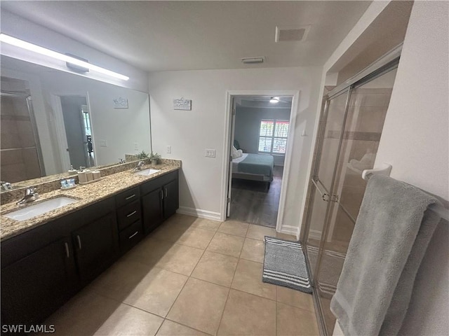 bathroom featuring tile patterned flooring, vanity, and a shower with door