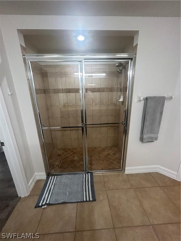 bathroom featuring tile patterned floors and a shower with shower door