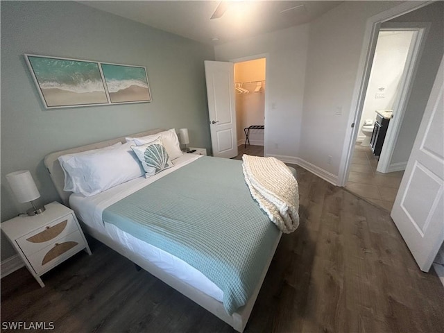 bedroom with ensuite bath, ceiling fan, dark hardwood / wood-style floors, a spacious closet, and a closet