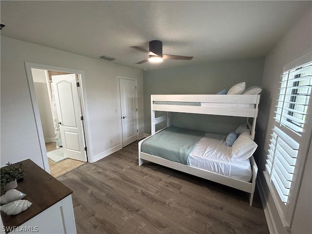 bedroom with ceiling fan, dark hardwood / wood-style floors, and connected bathroom