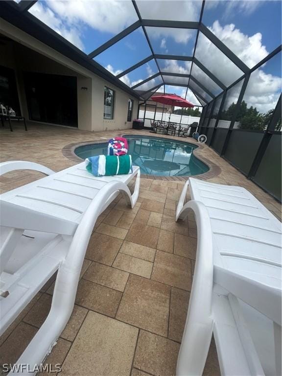 view of swimming pool with glass enclosure and a patio area