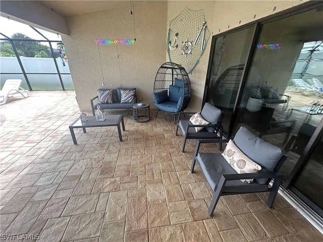 view of patio / terrace featuring glass enclosure and an outdoor living space