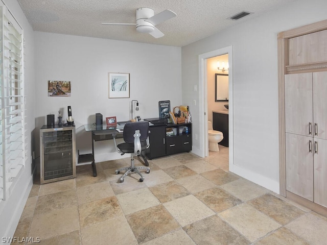 office with ceiling fan and a textured ceiling