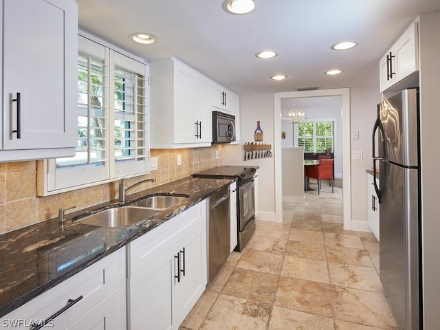 kitchen with backsplash, dark stone countertops, sink, white cabinetry, and appliances with stainless steel finishes