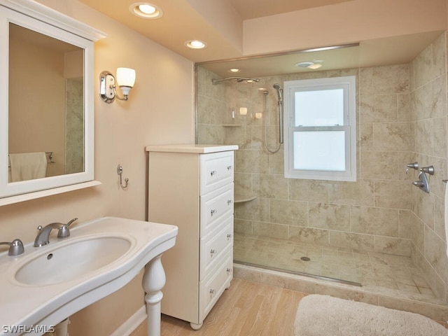 bathroom featuring sink, hardwood / wood-style floors, and a tile shower