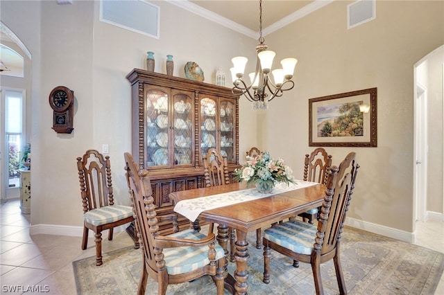 tiled dining space featuring a towering ceiling, crown molding, and a notable chandelier