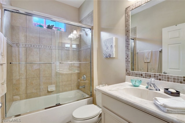 full bathroom featuring toilet, combined bath / shower with glass door, and vanity