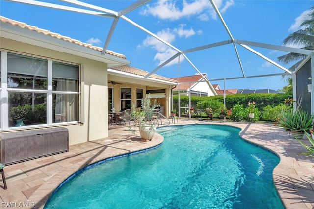 view of pool with ceiling fan, a patio area, and a lanai