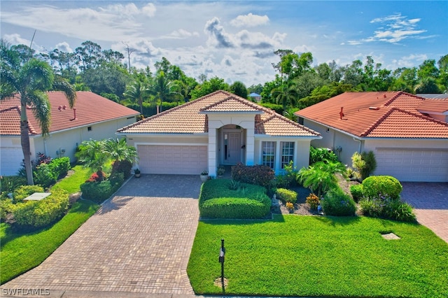 mediterranean / spanish-style home featuring a front lawn and a garage