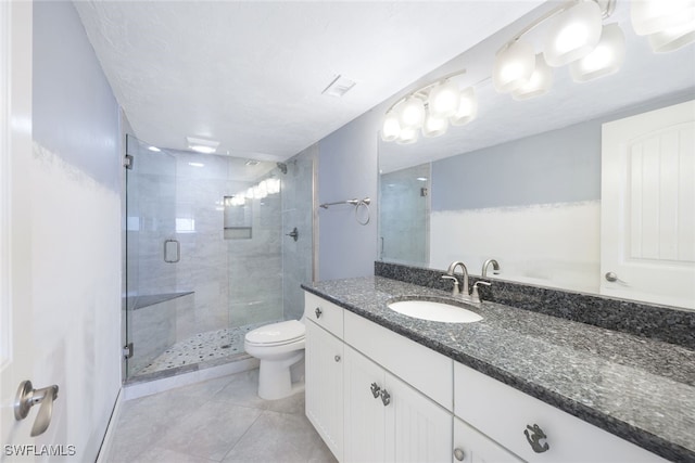 bathroom with vanity, toilet, tile patterned floors, and a shower with shower door