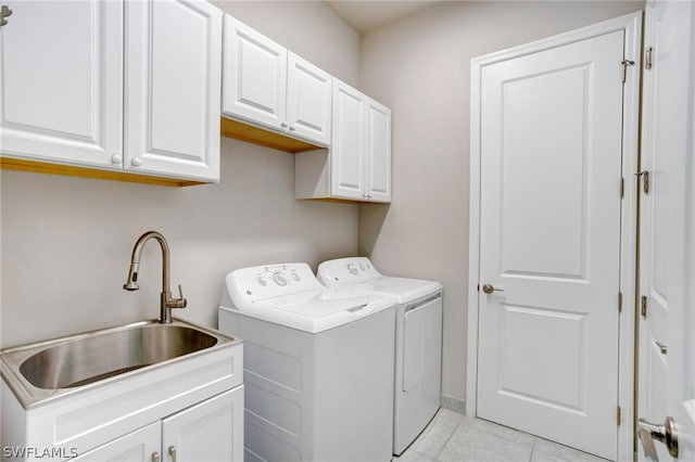 washroom with cabinets, independent washer and dryer, light tile patterned floors, and sink