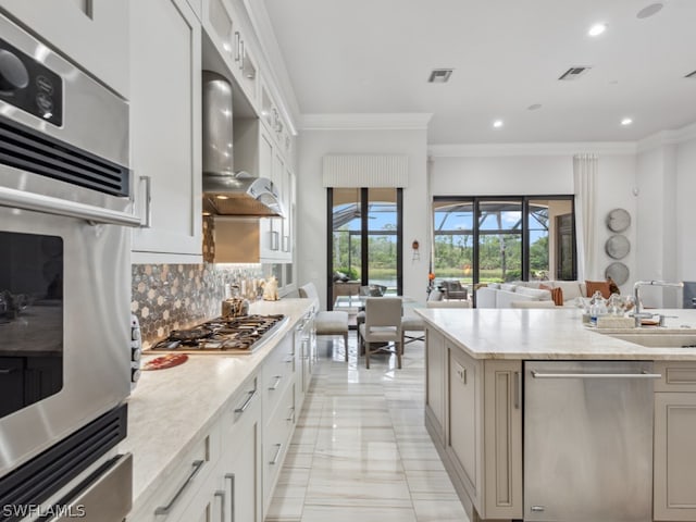 kitchen featuring white cabinetry, sink, light stone counters, decorative backsplash, and appliances with stainless steel finishes