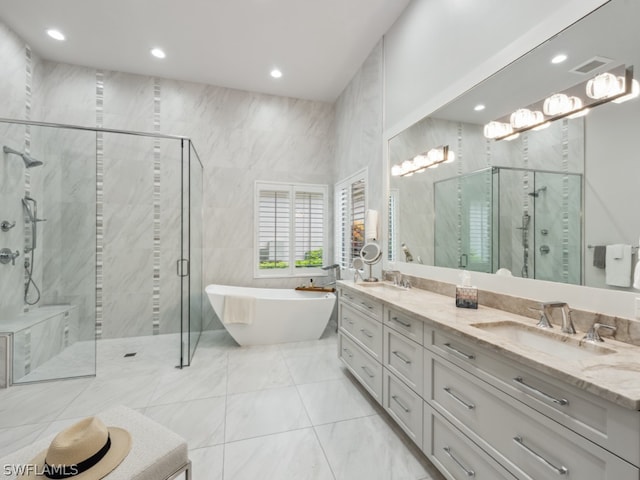 bathroom with separate shower and tub, vanity, and tile walls