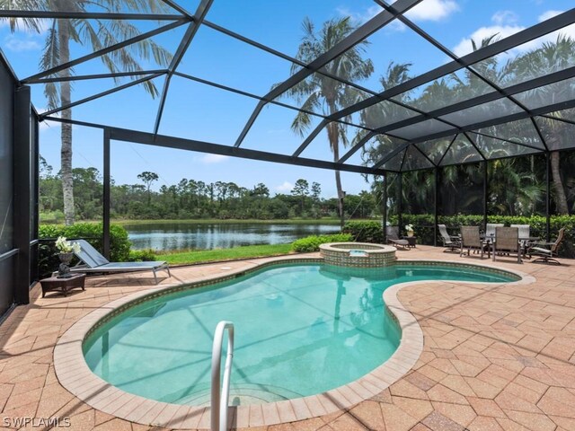 view of swimming pool with glass enclosure, a patio area, and a water view