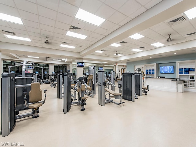 gym featuring ceiling fan and a drop ceiling