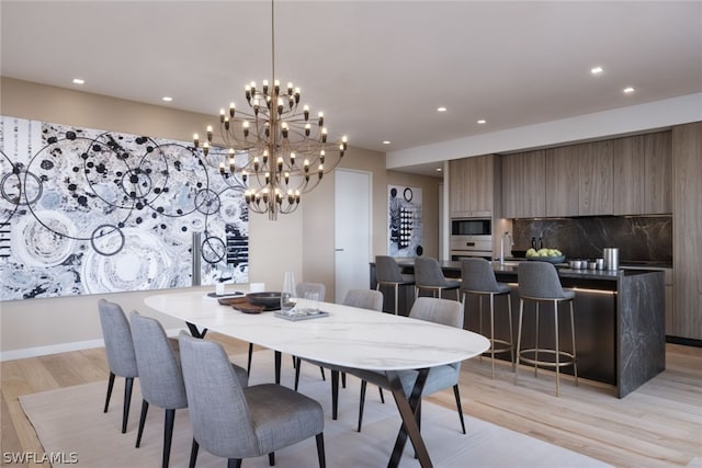 dining space with a chandelier and light hardwood / wood-style flooring